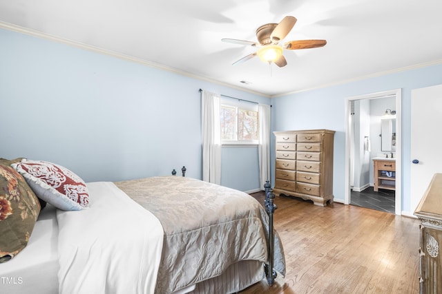 bedroom featuring crown molding, hardwood / wood-style floors, ceiling fan, and ensuite bath