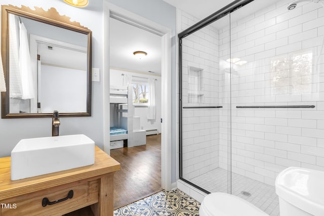 bathroom with walk in shower, a baseboard radiator, vanity, and toilet