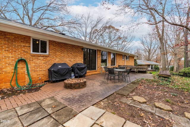 view of patio with area for grilling and a fire pit