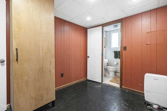 5205 Rembert Dr, Raleigh, NC 27612 - unfurnished bedroom with tile patterned floors, a baseboard heating unit, connected bathroom, and wooden walls