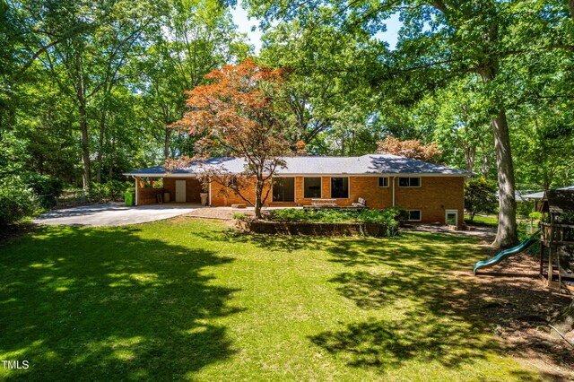 5205 Rembert Dr, Raleigh, NC 27612 - rear view of house with driveway, a playground, a lawn, and a carport