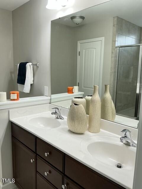 bathroom with a shower with door and vanity