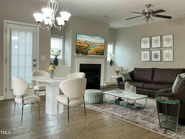 living area with dark hardwood / wood-style floors and ceiling fan with notable chandelier