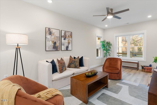 living room with ceiling fan and light hardwood / wood-style flooring