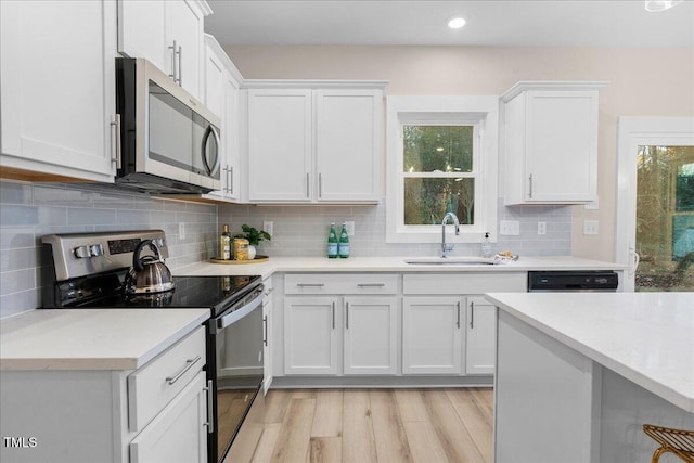 kitchen featuring backsplash, sink, white cabinetry, and stainless steel appliances