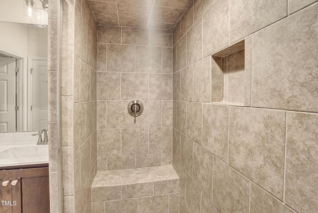 bathroom with vanity and tiled shower