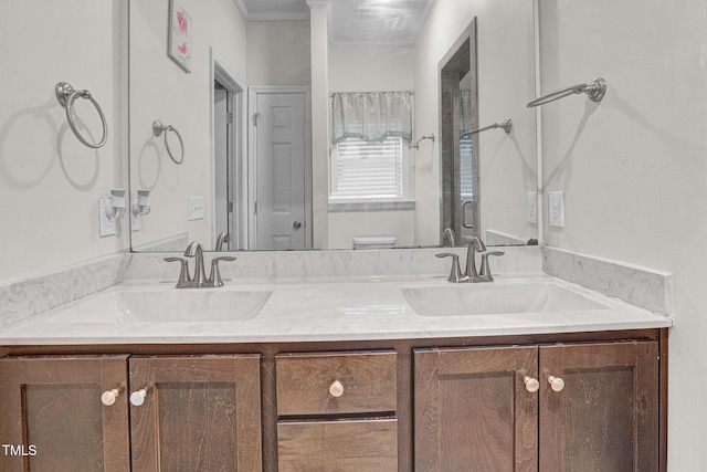 bathroom with crown molding, a shower with door, vanity, and toilet