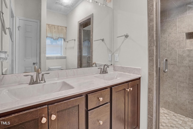 bathroom featuring toilet, vanity, a shower with shower door, and ornamental molding