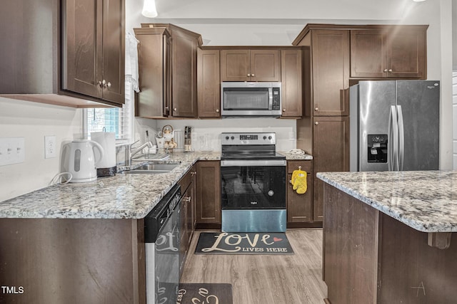 kitchen featuring light stone countertops, dark brown cabinets, stainless steel appliances, sink, and light hardwood / wood-style floors