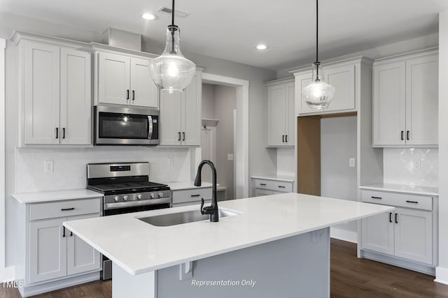 kitchen featuring pendant lighting, sink, an island with sink, and appliances with stainless steel finishes