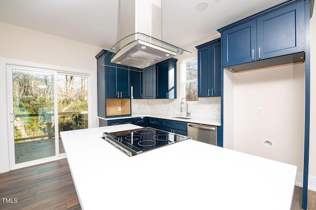 kitchen featuring cooktop, island exhaust hood, stainless steel dishwasher, and blue cabinets