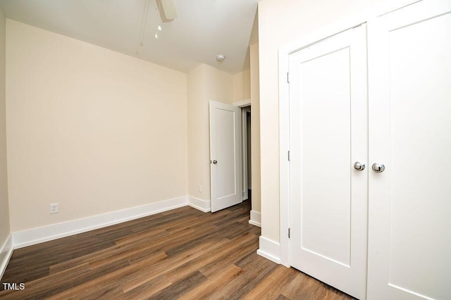 unfurnished bedroom with hardwood / wood-style floors, a closet, and ceiling fan