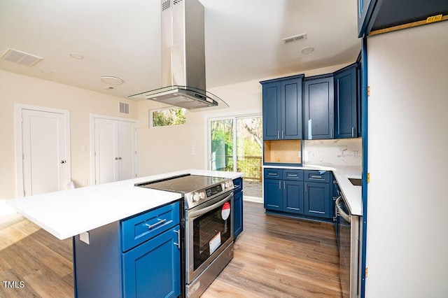 kitchen featuring a kitchen island, blue cabinetry, tasteful backsplash, island range hood, and stainless steel appliances