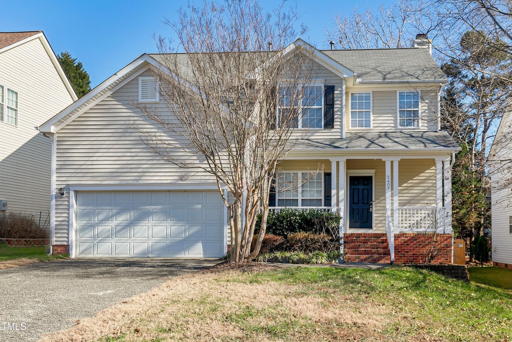 view of front of property with covered porch, a garage, and a front yard