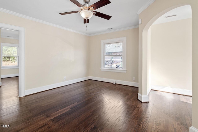 empty room with ceiling fan, plenty of natural light, crown molding, and dark hardwood / wood-style floors