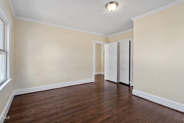 empty room featuring dark hardwood / wood-style flooring and ornamental molding