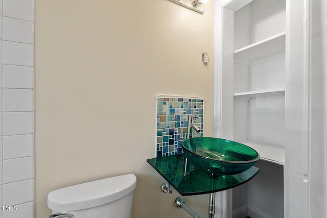 bathroom featuring sink, decorative backsplash, and toilet