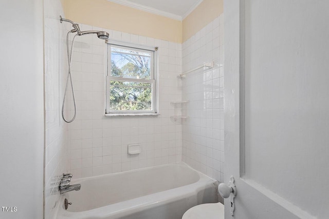 bathroom featuring toilet, tiled shower / bath combo, and crown molding