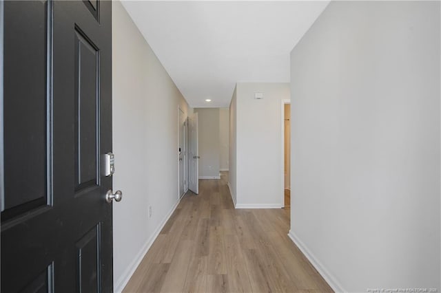 corridor with light hardwood / wood-style floors