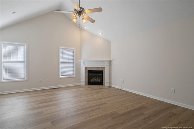 unfurnished living room with a fireplace, light wood-type flooring, ceiling fan, and lofted ceiling