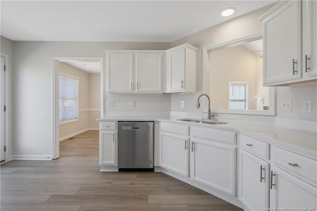 kitchen with dishwasher, light wood-type flooring, white cabinets, and sink