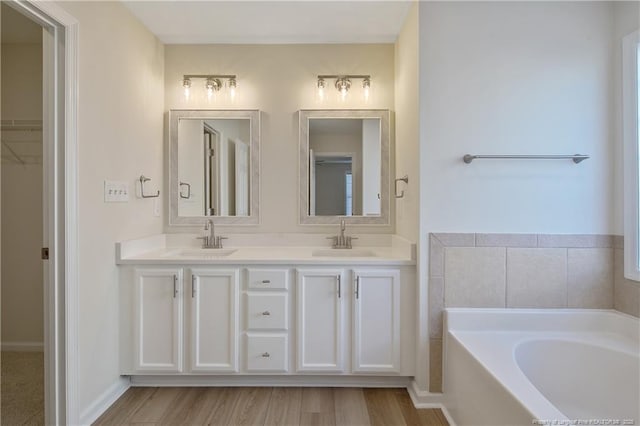 bathroom featuring a bath, vanity, and wood-type flooring