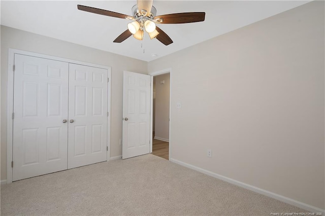 unfurnished bedroom with ceiling fan, a closet, and light colored carpet