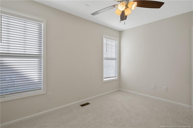 carpeted spare room with ceiling fan