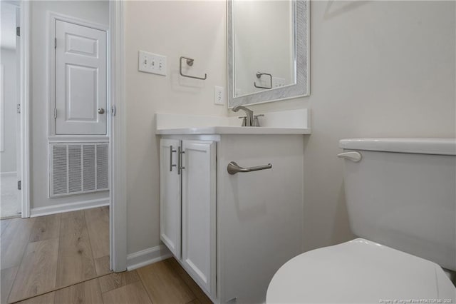 bathroom featuring hardwood / wood-style floors, vanity, and toilet