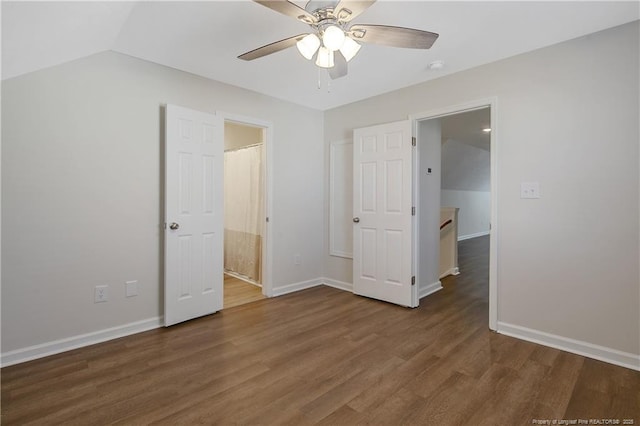 unfurnished bedroom with dark hardwood / wood-style floors, ceiling fan, lofted ceiling, and ensuite bathroom