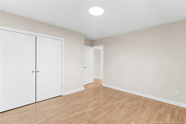 unfurnished bedroom featuring a closet and light hardwood / wood-style flooring