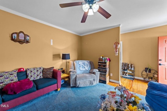 living area featuring baseboards, wood finished floors, a ceiling fan, and crown molding