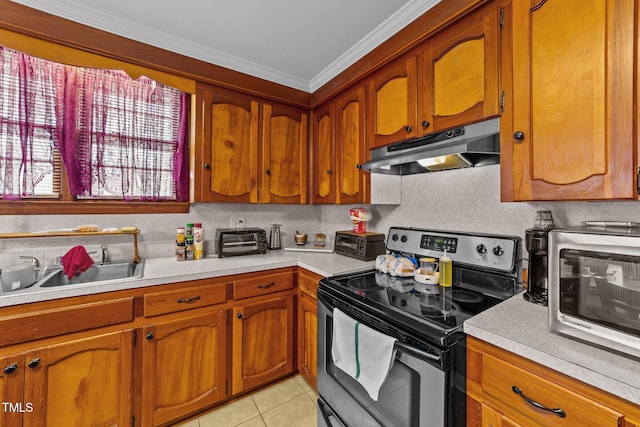 kitchen with brown cabinetry, ornamental molding, stainless steel appliances, light countertops, and under cabinet range hood