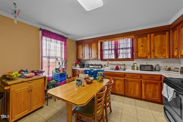 kitchen with light tile patterned floors, electric stove, light countertops, and crown molding