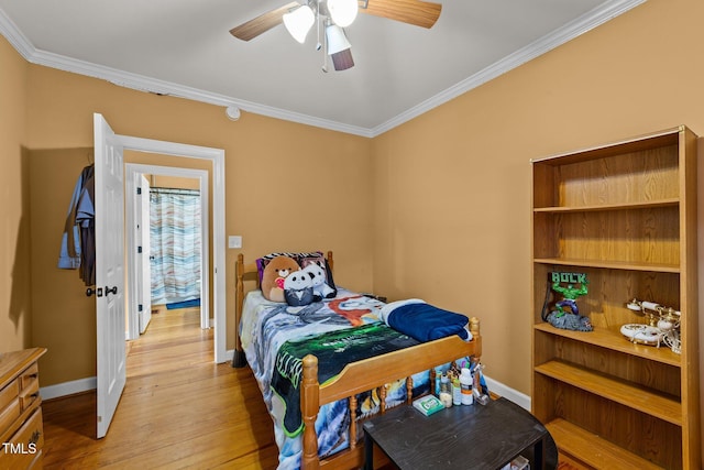 bedroom featuring light wood-style floors, crown molding, baseboards, and ceiling fan