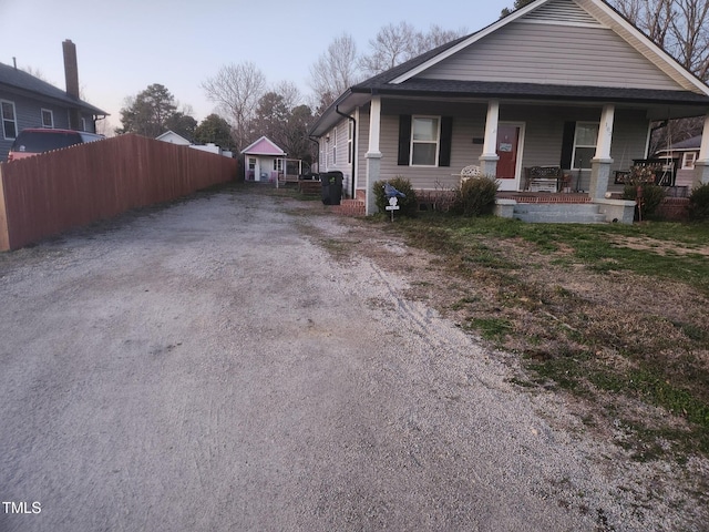 view of front of property with covered porch and fence