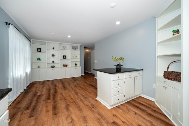 kitchen with white cabinets, kitchen peninsula, and hardwood / wood-style flooring