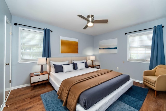 bedroom with ceiling fan, dark hardwood / wood-style floors, and multiple windows