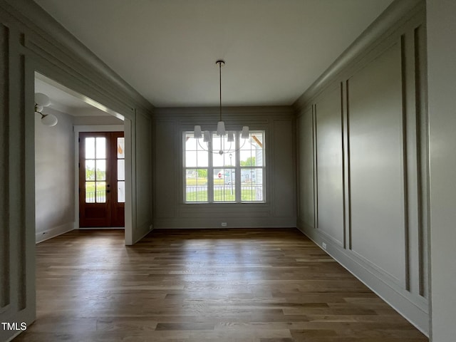 25 Deer Tail Ln Lot 52, Fuquay Varina, NC 27526 - unfurnished dining area featuring a chandelier, a decorative wall, wood finished floors, and baseboards