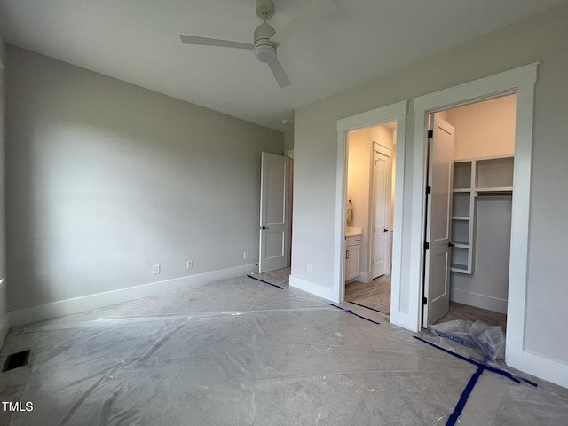 25 Deer Tail Ln Lot 52, Fuquay Varina, NC 27526 - unfurnished bedroom featuring baseboards, concrete floors, a walk in closet, ensuite bath, and a closet