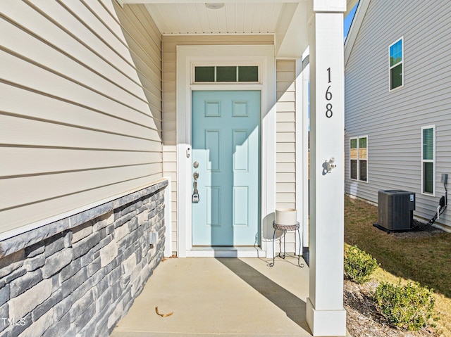 view of exterior entry featuring central AC unit