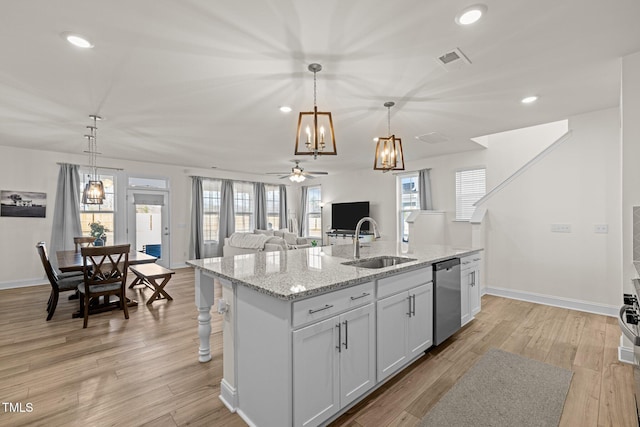 kitchen featuring dishwasher, an island with sink, ceiling fan, pendant lighting, and sink