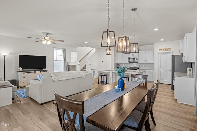 dining area with light wood-type flooring and ceiling fan