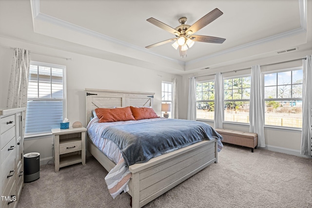 bedroom with a raised ceiling, ceiling fan, crown molding, and light carpet