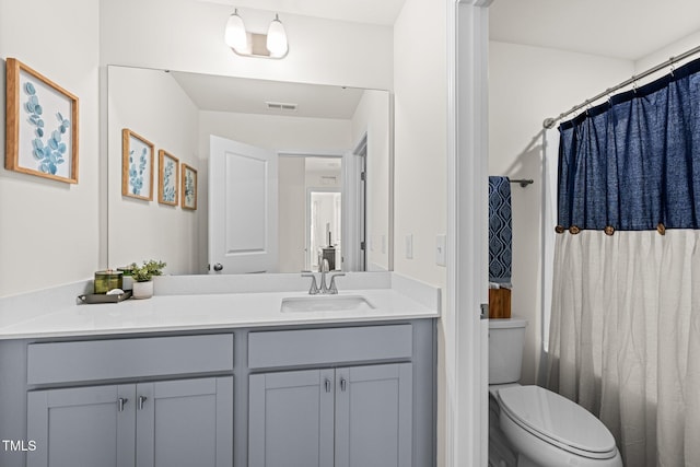 bathroom featuring toilet, vanity, and a shower with curtain