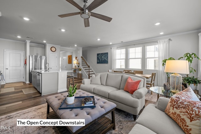 living room featuring dark hardwood / wood-style floors, ceiling fan, and crown molding