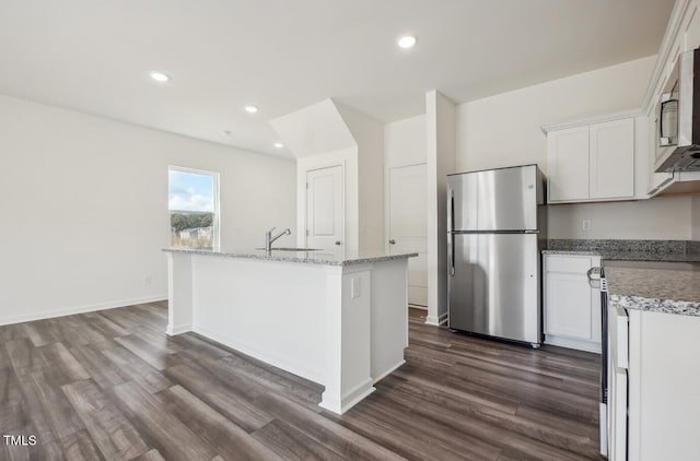 kitchen with dark wood-type flooring, white cabinetry, stainless steel appliances, sink, and a kitchen island with sink