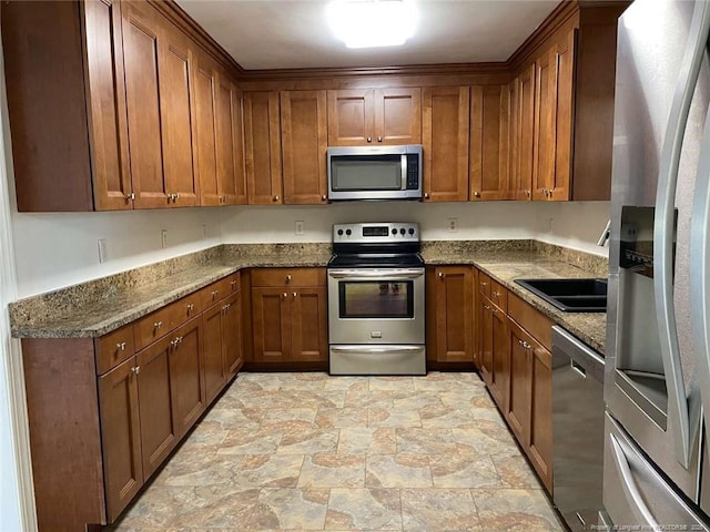 kitchen featuring sink, dark stone countertops, and stainless steel appliances