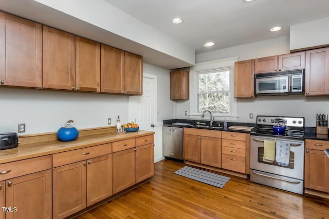 kitchen with stainless steel appliances, light hardwood / wood-style flooring, and sink