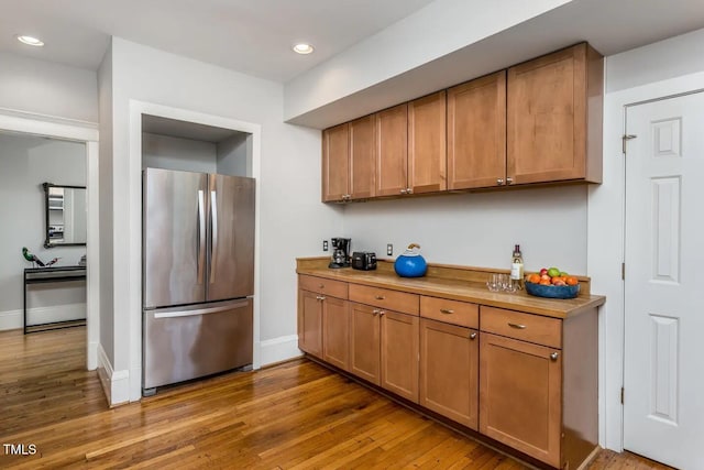 kitchen with stainless steel fridge and hardwood / wood-style flooring